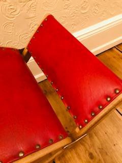 Repose-pieds à bascule ancien, structure bois, revêtement en similicuir rouge, pliable, réglable en hauteur, dimensions : L 65 cm, P 34 cm.