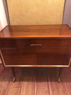 Meuble bar à roulettes, verni, porte à abattant, 3 étagères de rangement, compartiment bouteilles éclairé, années 60-70, dimensions : L 86 cm, H 74, P 40,5.