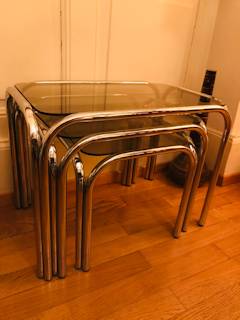 Série de 3 tables gigognes, inox et verre fumé, dimensions de la grande L 54, l 34,5, H 40; moyenne L 44,5, l 34,5, H 36; petite L 43,5, l 34,5, H 32.