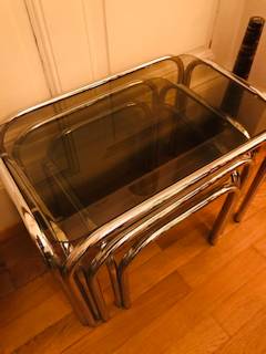 Série de 3 tables gigognes, inox et verre fumé, dimensions de la grande L 54, l 34,5, H 40; moyenne L 44,5, l 34,5, H 36; petite L 43,5, l 34,5, H 32.