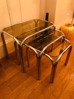 Série de 3 tables gigognes, inox et verre fumé, dimensions de la grande L 54, l 34,5, H 40; moyenne L 44,5, l 34,5, H 36; petite L 43,5, l 34,5, H 32.